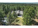 Stunning aerial view of a home surrounded by lush greenery and mature trees in a private setting at 4726 Pinon Dr, Elizabeth, CO 80107