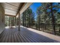Large, covered deck features wood flooring and views of the trees at 4726 Pinon Dr, Elizabeth, CO 80107