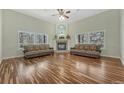 Cozy living room with hardwood floors, a fireplace, and large windows with wooded views at 4726 Pinon Dr, Elizabeth, CO 80107