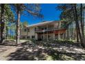 A large, two-story home features a backyard in a wooded setting, along with a spacious, elevated deck with black metal railings at 4726 Pinon Dr, Elizabeth, CO 80107