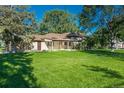 Inviting home boasting a large, green front yard with mature trees and brick exterior at 5982 S Aberdeen St, Littleton, CO 80120