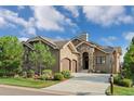 Charming home featuring a stone facade, manicured landscaping, and a driveway leading to a two-car garage at 5149 Le Duc Ln, Castle Rock, CO 80108