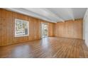 Spacious living room with wood paneled walls, beamed ceilings, and sliding door to patio at 9700 E Iliff Ave # B13, Denver, CO 80231