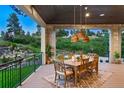 Inviting outdoor space, perfect for dining, features wood ceiling, stone columns and scenic views of lush greenery at 2130 Avenida Del Sol, Castle Rock, CO 80104