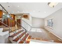 Open-concept living area with wooden staircase, neutral paint, a wine rack and natural light from a window at 6545 S Balsam Ct, Littleton, CO 80123