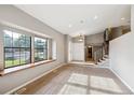 Bright and airy living space featuring a large window, carpet, and a clear view of the entryway and stairs at 6545 S Balsam Ct, Littleton, CO 80123
