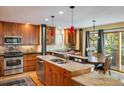 Well-lit kitchen with granite counters, a stainless-steel dishwasher, and wood cabinets at 5523 Stonewall Pl, Boulder, CO 80303