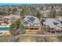 Aerial view of the luxury home with solar panels and a large deck overlooking the manicured backyard at 32 Silver Fox Cir, Greenwood Village, CO 80121