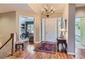 Elegant foyer with hardwood floors, chandelier, and a view into a bright office space at 32 Silver Fox Cir, Greenwood Village, CO 80121