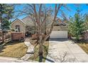 Charming home featuring a well-manicured lawn, brick accents, and a spacious two-car garage at 32 Silver Fox Cir, Greenwood Village, CO 80121