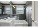Modern bathroom with gray tiles, a glass-enclosed tub/shower combination, and a sleek vanity at 1376 Ivanhoe St, Denver, CO 80220