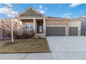 Attractive single-Gathering home with stone accents, a covered porch, and a three-car garage against a blue sky at 1588 Blackwood Ct, Erie, CO 80516