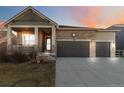 Charming single-Gathering home with stone accents, a covered porch, a three-car garage, and manicured landscaping at 1588 Blackwood Ct, Erie, CO 80516