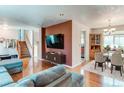 Open-concept living room with wood floors, a staircase, and a dining area nearby at 2863 S Biscay Ct, Aurora, CO 80013