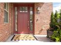 Charming front door entrance with sidelights and a welcome mat on the front porch at 6485 E Cedar Ave, Denver, CO 80224
