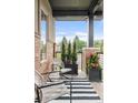Inviting front porch with stylish furniture, planters, and a striped rug at 6485 E Cedar Ave, Denver, CO 80224