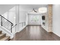 Open living area with stone accent wall, modern fireplace, wood floors, and modern light fixtures at 6485 E Cedar Ave, Denver, CO 80224
