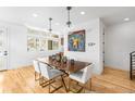 Bright dining room with modern lighting fixtures, a wood table, and white chairs at 553 Monroe St, Denver, CO 80206