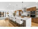 Bright kitchen features a large island with seating, modern appliances, and wood cabinetry at 553 Monroe St, Denver, CO 80206