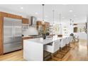 Bright kitchen features a large island with seating, modern appliances, and wood cabinetry at 553 Monroe St, Denver, CO 80206