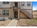 Exterior view of unit entrance with stairs leading to a balcony and xeriscaping at 4474 Copeland Cir # 102, Highlands Ranch, CO 80126
