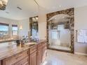 Spacious bathroom featuring granite countertops, a mirror, and a glass enclosed shower with tile arch at 5603 Twilight Way, Parker, CO 80134
