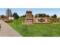 Attractive community entrance with stone signage, manicured lawn and directional sales office arrow at 5603 Twilight Way, Parker, CO 80134