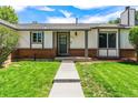 Inviting entryway with a well-kept lawn, brick details, and a freshly painted front door at 17177 E Milan Cir, Aurora, CO 80013