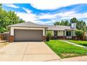 Lovely single-story home with a large, two-car garage, brick accents, and lush green lawn at 17177 E Milan Cir, Aurora, CO 80013