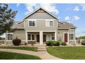 Inviting home featuring a well-maintained lawn, concrete pathway, and cozy entranceways at 805 Summer Hawk Dr # 100, Longmont, CO 80504