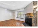 Bright living room showcasing hardwood floors, fireplace, and large window with natural light at 1209 S Flower Cir # C, Lakewood, CO 80232