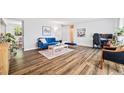 Bright living room with hardwood floors, a comfortable blue sofa, and abundant natural light, perfect for relaxation at 5054 W 61St Dr, Arvada, CO 80003