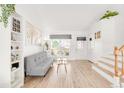 Bright living room showcasing light wood floors, a large window, and a cozy gray sofa at 4534 Nepal St, Denver, CO 80249