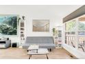 Inviting living room featuring wood floors, a large window, and a comfortable gray sofa at 4534 Nepal St, Denver, CO 80249