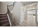Open entryway with hardwood floors, staircase with black metal railings, and modern doors at 774 Anderson St, Lochbuie, CO 80603