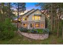 Lovely home with mature trees and stone retaining wall surrounded by lush landscaping at 315 Prospect Dr, Castle Rock, CO 80108