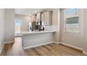 Well-lit kitchen featuring stainless steel appliances, white countertop, and hardwood floors at 18318 E 93Rd Pl, Commerce City, CO 80022