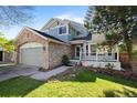 Inviting two-story home with a stone-accented facade, two-car garage, and cozy front porch at 10519 Winterflower Way, Parker, CO 80134