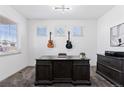 Home office with a large desk, guitars on the wall, and ample natural light from three windows at 1301 Sidewinder Cir, Castle Rock, CO 80108