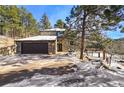 Charming stone home features an attached two-car garage and a welcoming entrance, complete with a stone walkway at 4398 Cameyo Rd, Indian Hills, CO 80454