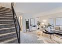 Bright living room with carpet, stylish decor, and easy access to the staircase at 5511 S Lowell Blvd, Littleton, CO 80123