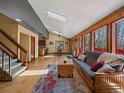 Bright living room featuring wood floors, a skylight, and views of the surrounding forest at 10852 Conifer Mountain Rd, Conifer, CO 80433