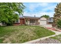 Charming single-story home with brick accents, manicured lawn, and attached garage at 1828 Stratford Ln, Longmont, CO 80503