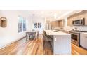 A modern kitchen with stainless steel appliances, an island with seating, and a dining area with natural light at 822 Fairfax St, Denver, CO 80220
