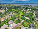 Panoramic aerial view of a neighborhood surrounded by lush greenery and a large lake in the distance at 8165 W Stene Dr, Littleton, CO 80128