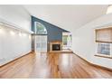 Bright living room features a cozy fireplace, hardwood floors, and ample natural light at 10729 Kipling Way, Broomfield, CO 80021