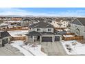 Two-story house with gray siding, three-car garage, and backyard at 11633 Norfolk St, Commerce City, CO 80022