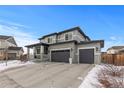 Two-story house with gray siding, three-car garage, and snowy driveway at 11633 Norfolk St, Commerce City, CO 80022