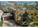 Aerial view of home featuring a lush front lawn, large trees, and a two-car garage at 2838 Forest St, Denver, CO 80207