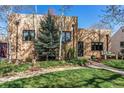 Brick home with a well-manicured lawn, garden and covered front porch at 2838 Forest St, Denver, CO 80207